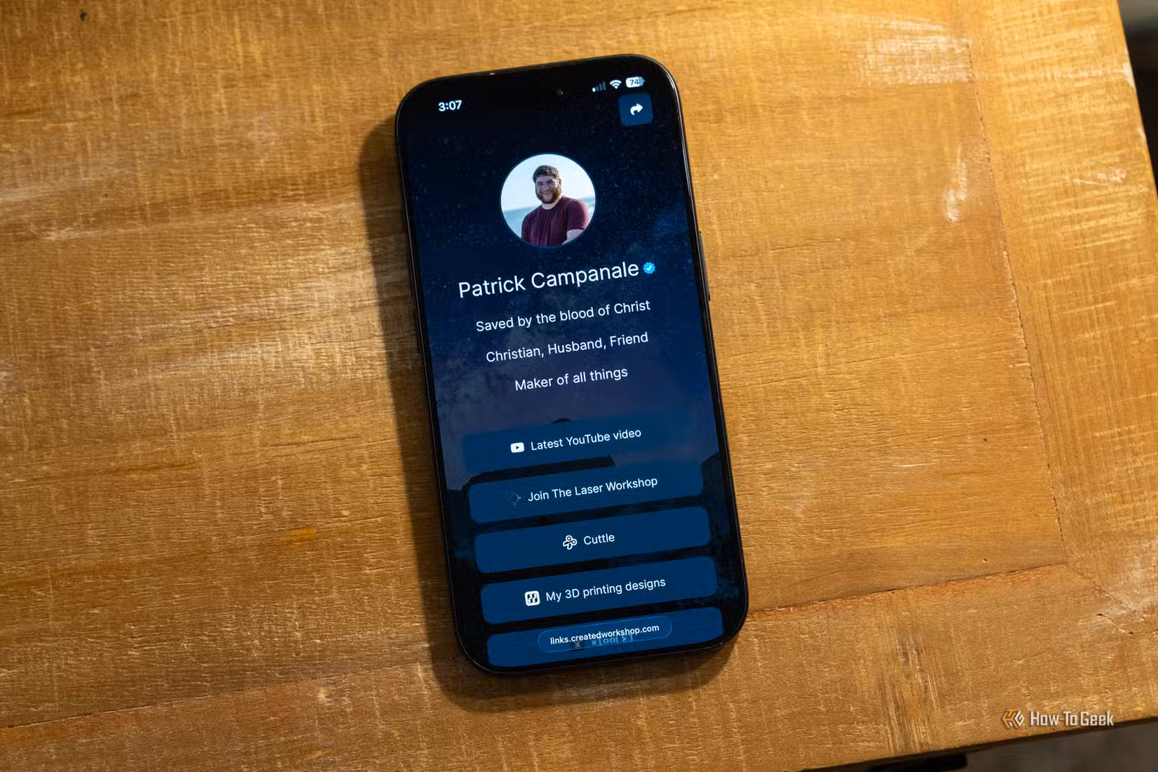 A LinkStack landing page being shown on an iPhone 17 Pro sitting on a wooden desk.