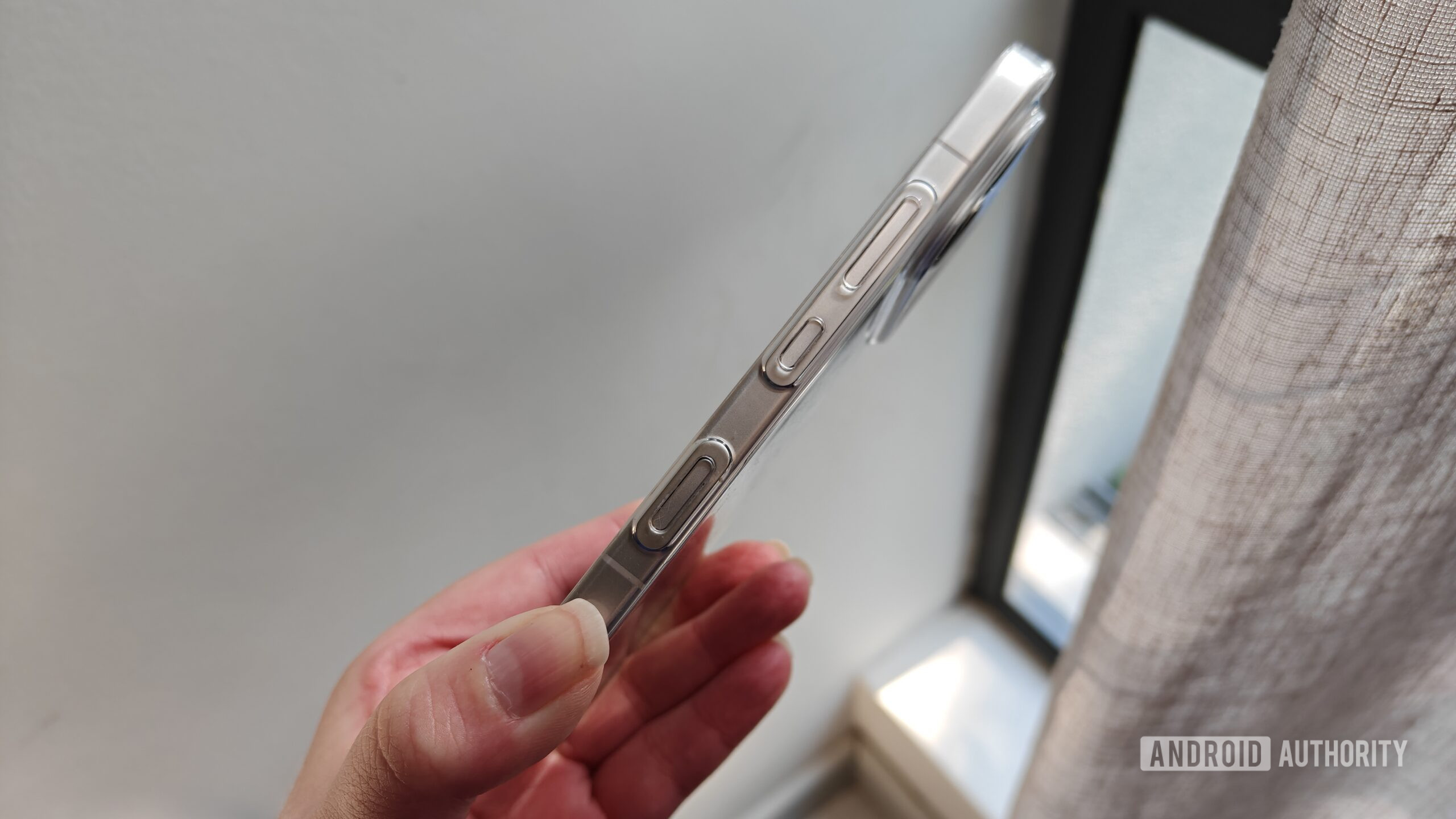 a phone held in a hand showing its side buttons